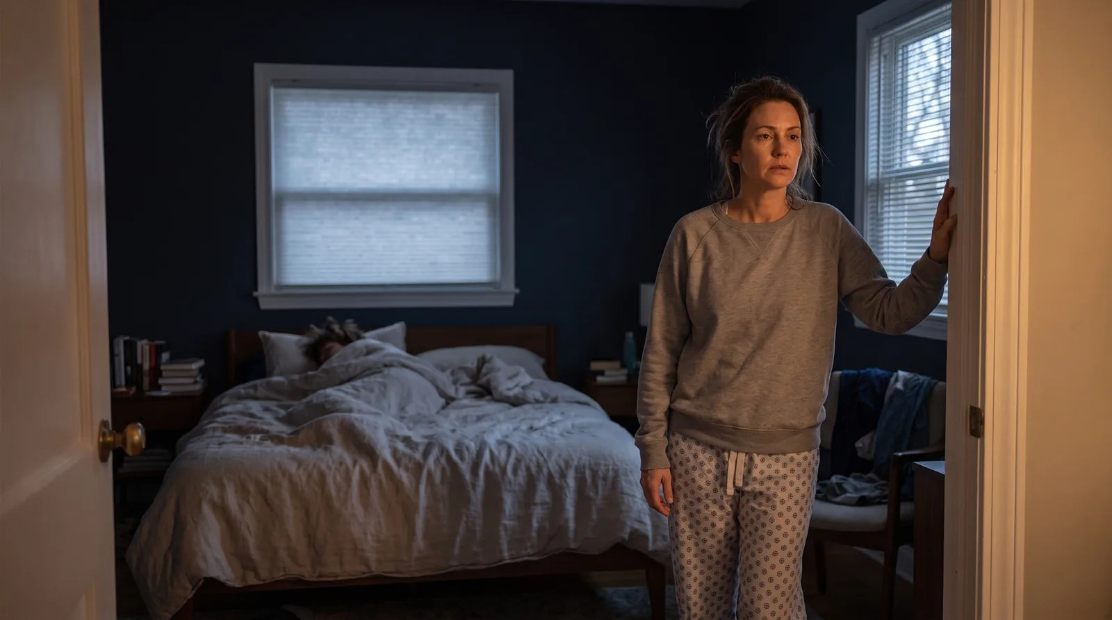 Parent standing in a bedroom doorway at dawn